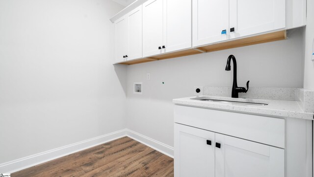washroom with hookup for a washing machine, cabinet space, dark wood-style floors, and baseboards