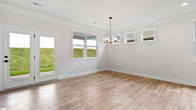 unfurnished dining area with a chandelier, ornamental molding, baseboards, and light wood-style flooring