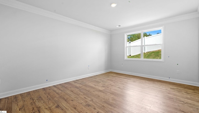 unfurnished room featuring ornamental molding, baseboards, and light wood-style flooring