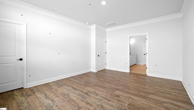 unfurnished bedroom featuring ornamental molding, wood finished floors, baseboards, and ensuite bathroom