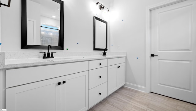 full bath with baseboards and double vanity