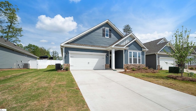 craftsman house with cooling unit, driveway, stone siding, and an attached garage