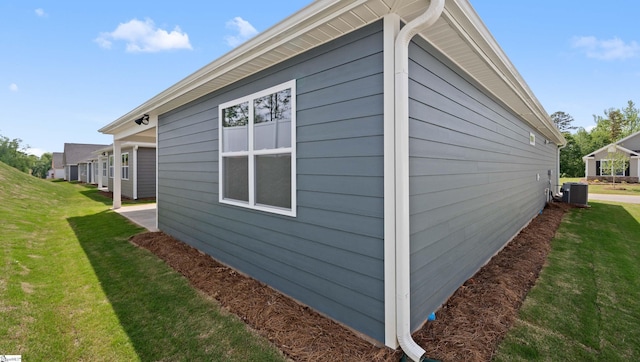 view of side of home featuring a yard and central AC