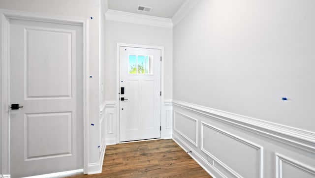 entryway featuring crown molding, dark wood-style flooring, a decorative wall, and wainscoting