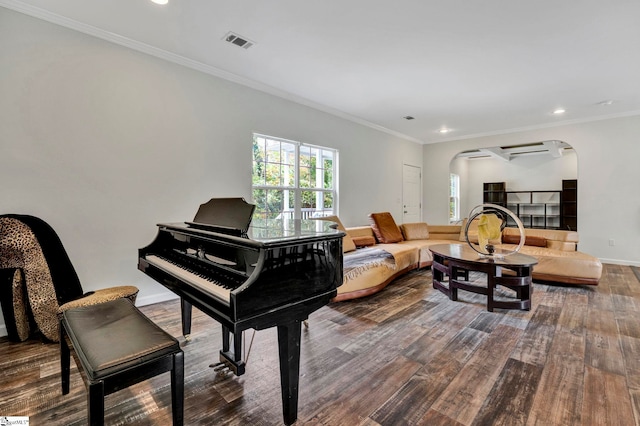 sitting room featuring arched walkways, crown molding, dark wood finished floors, visible vents, and baseboards