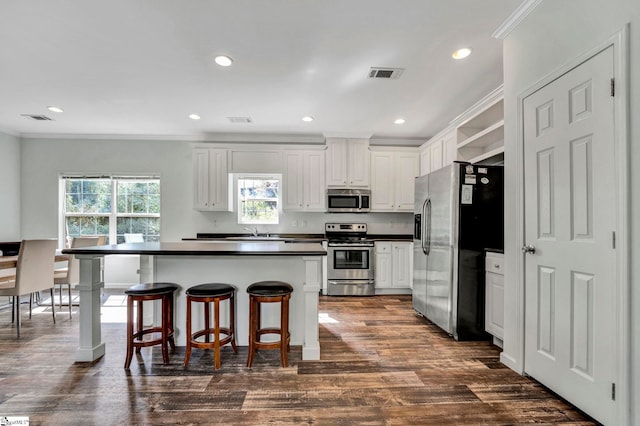 kitchen with dark countertops, visible vents, appliances with stainless steel finishes, and dark wood-type flooring