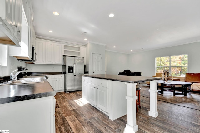 kitchen with dark countertops, dark wood-type flooring, stainless steel appliances, white cabinetry, and open shelves