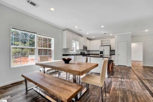 dining space with dark wood-style floors, visible vents, ornamental molding, and baseboards