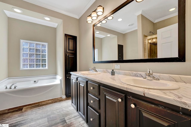 full bath with double vanity, ornamental molding, a sink, wood finished floors, and a bath