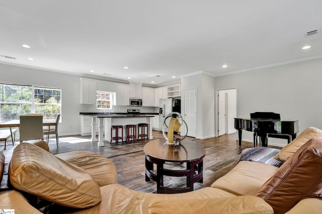 living room featuring crown molding, recessed lighting, visible vents, and baseboards