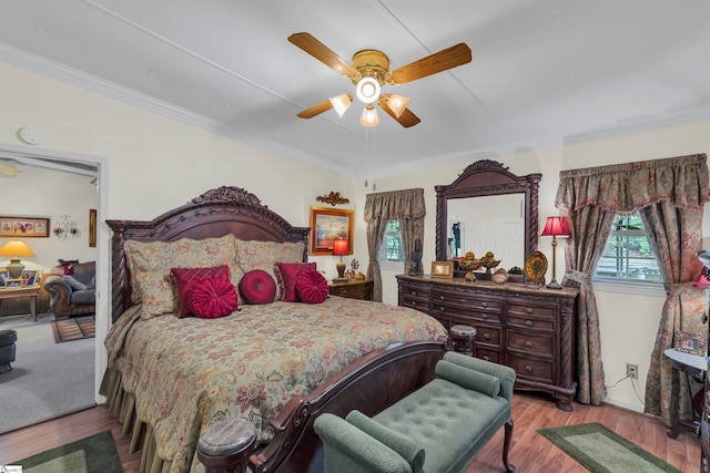 bedroom with light hardwood / wood-style flooring, ceiling fan, and ornamental molding