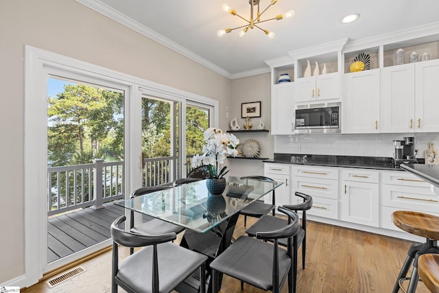 interior space featuring an inviting chandelier, light hardwood / wood-style flooring, and ornamental molding