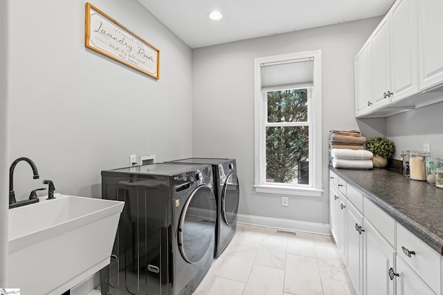 clothes washing area with sink, light tile patterned floors, cabinets, and independent washer and dryer