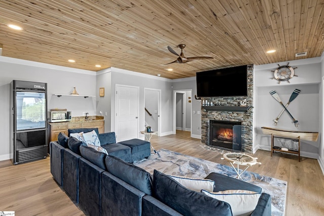 living room with ceiling fan, light hardwood / wood-style flooring, wood ceiling, a fireplace, and crown molding