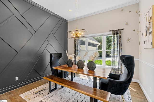 dining room featuring hardwood / wood-style floors, ornamental molding, and a chandelier