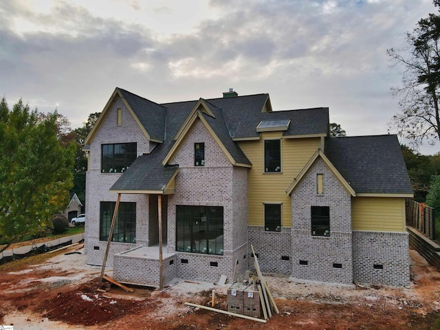 view of front facade featuring crawl space, brick siding, and a chimney