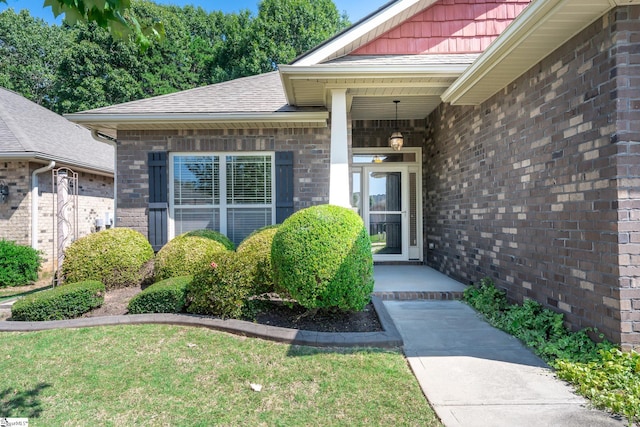 view of exterior entry with a yard