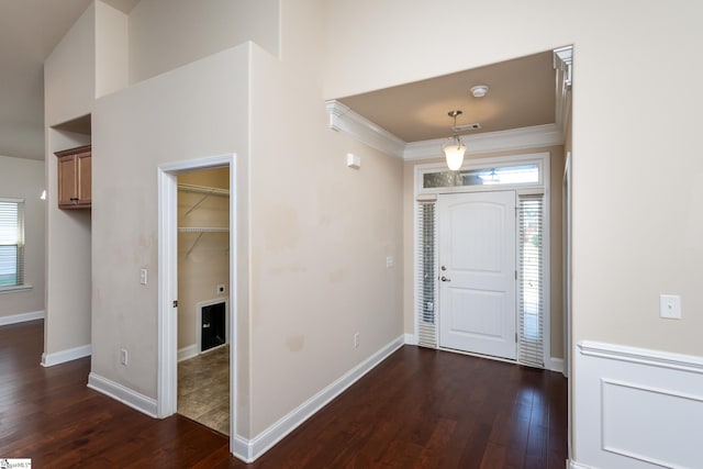 foyer with dark hardwood / wood-style floors and crown molding