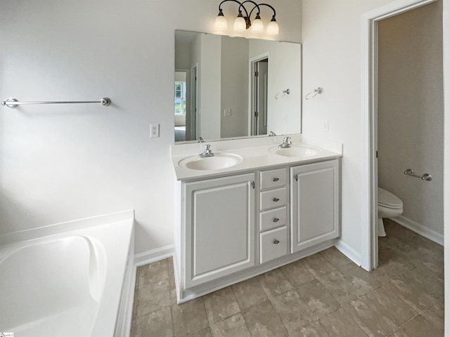 bathroom featuring toilet, a garden tub, double vanity, and a sink