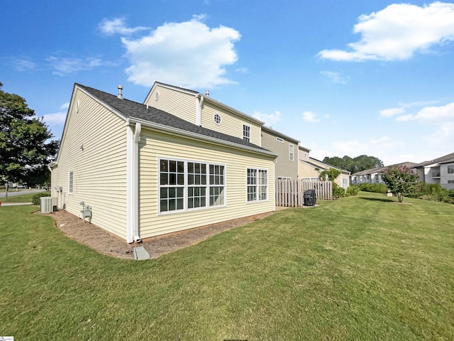 back of property with a yard and central AC unit