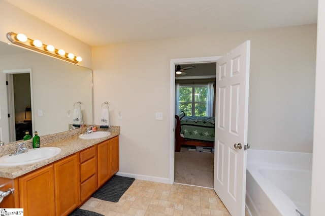 bathroom featuring tile patterned floors, a bathing tub, vanity, and ceiling fan