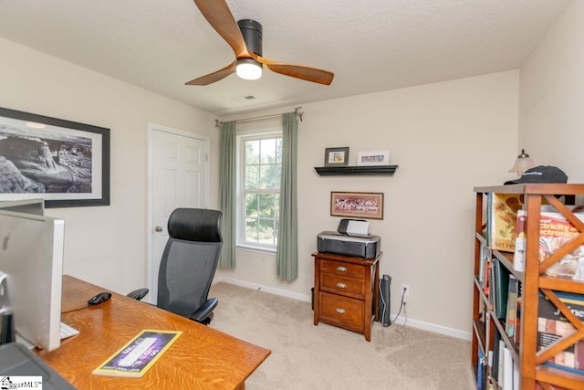 carpeted home office with ceiling fan and a textured ceiling