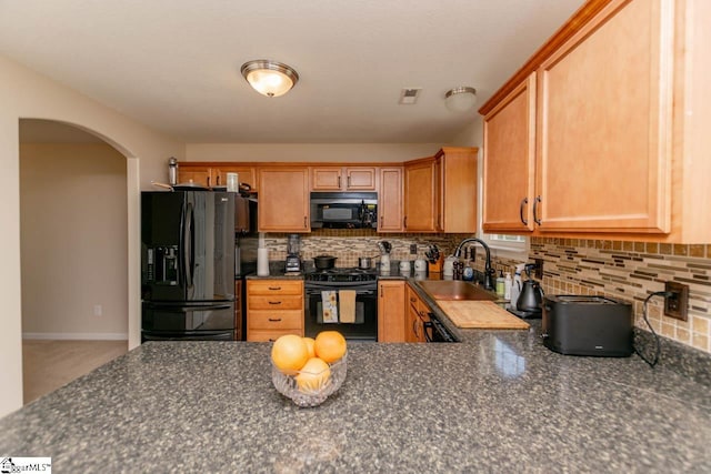 kitchen with sink, decorative backsplash, and black appliances