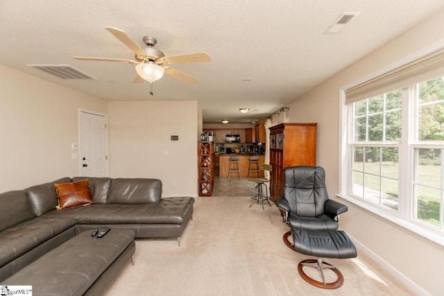 carpeted living room featuring ceiling fan and plenty of natural light