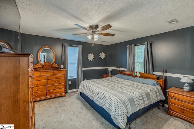 bedroom featuring a textured ceiling, ceiling fan, and carpet