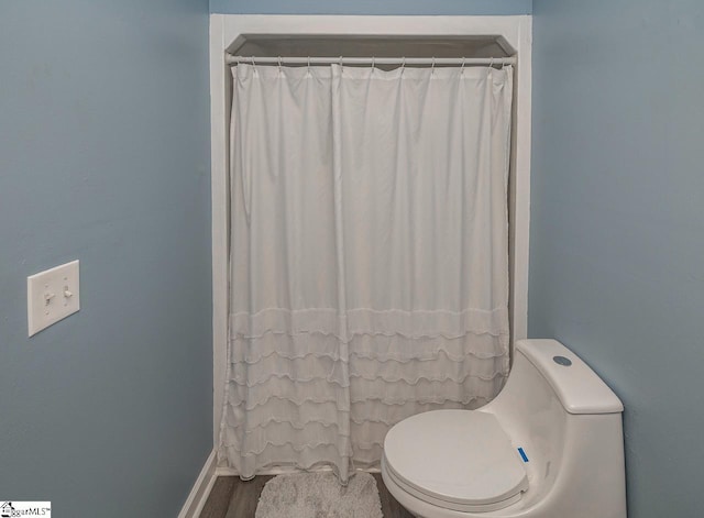 bathroom featuring toilet and a shower with shower curtain