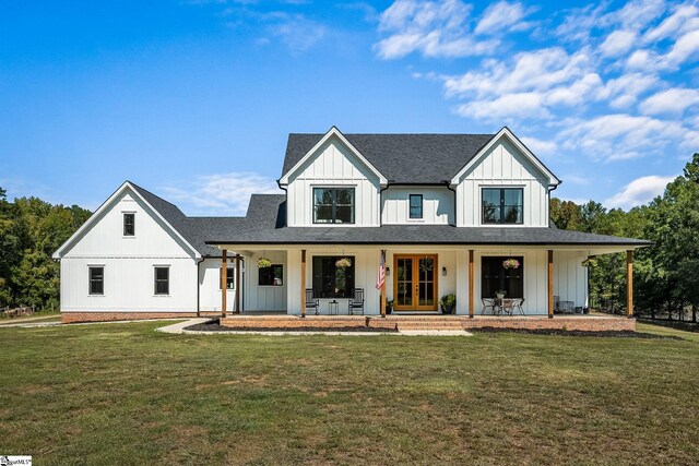 modern farmhouse style home with a front lawn and covered porch