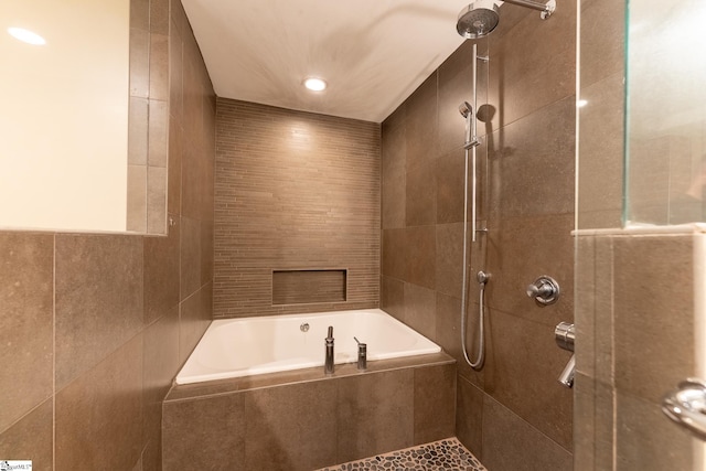 bathroom featuring tile walls and independent shower and bath