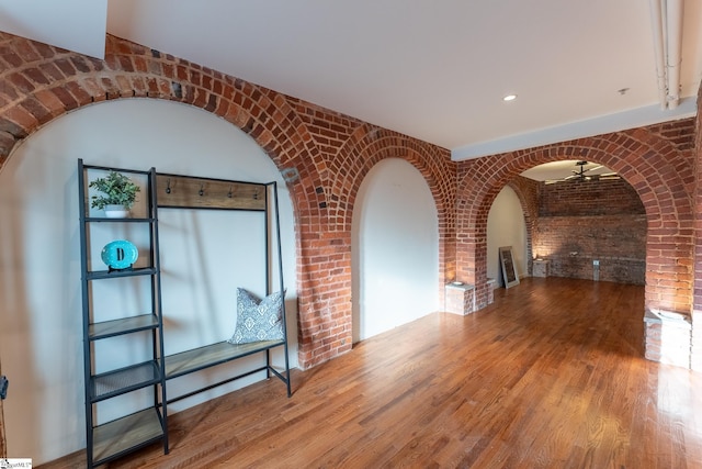 interior space with brick wall and wood-type flooring