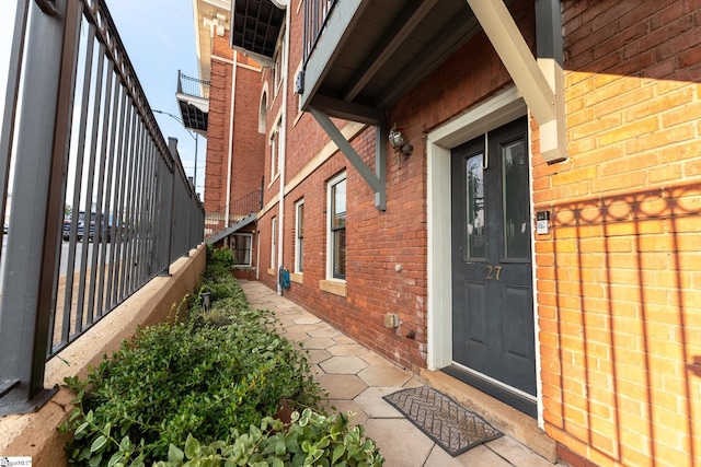 property entrance with brick siding and fence