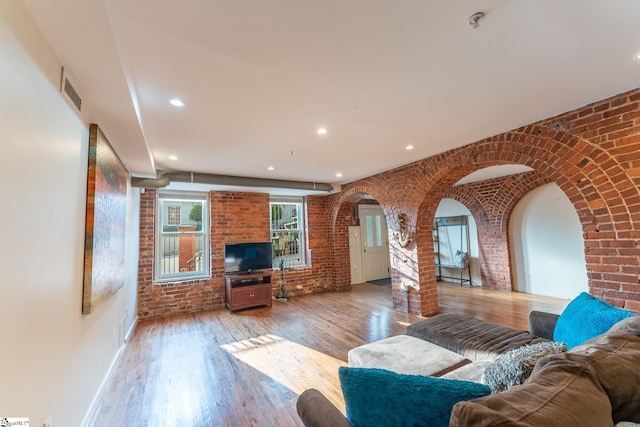 living room featuring hardwood / wood-style floors and brick wall