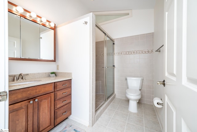 bathroom featuring toilet, a stall shower, vanity, and tile patterned floors