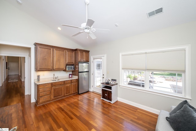 kitchen with a sink, visible vents, light countertops, appliances with stainless steel finishes, and brown cabinetry