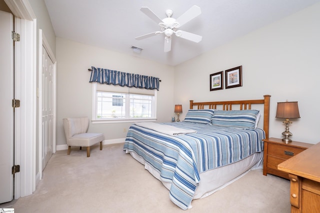 carpeted bedroom with baseboards, visible vents, and a ceiling fan