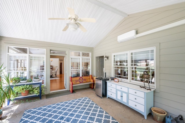 sunroom with vaulted ceiling, a wall mounted AC, and a ceiling fan