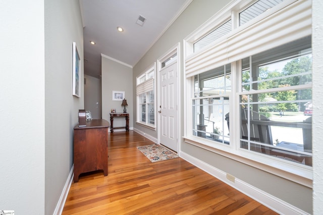 entrance foyer featuring ornamental molding, light wood-style floors, visible vents, and baseboards