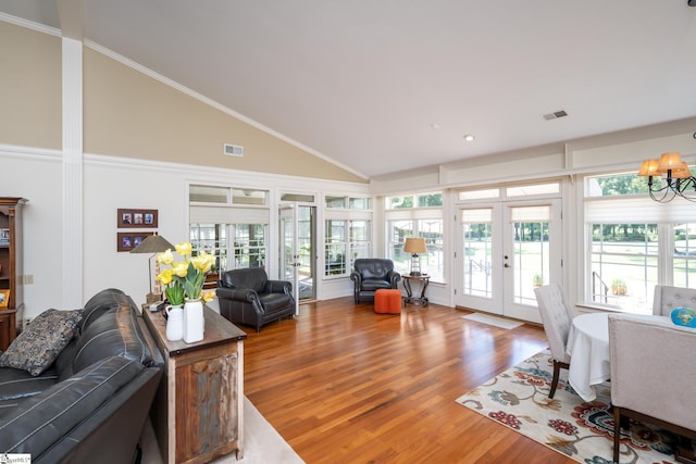 living room with crown molding, visible vents, wood finished floors, and french doors