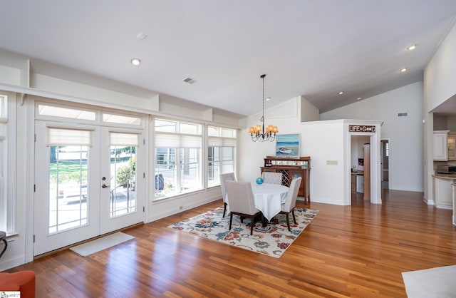 dining room featuring a chandelier, a wealth of natural light, french doors, and wood finished floors