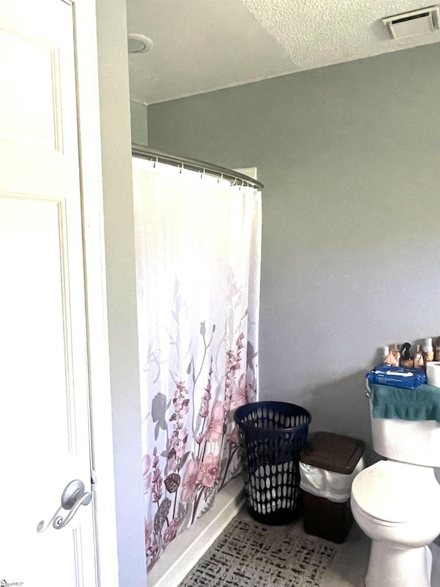 bathroom featuring curtained shower and toilet