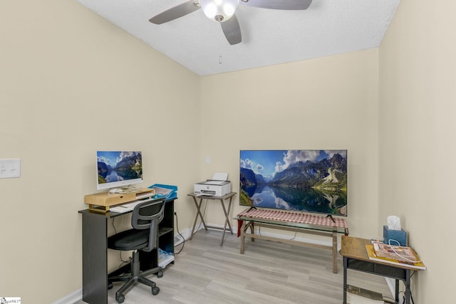 office featuring a textured ceiling, ceiling fan, and light wood-type flooring