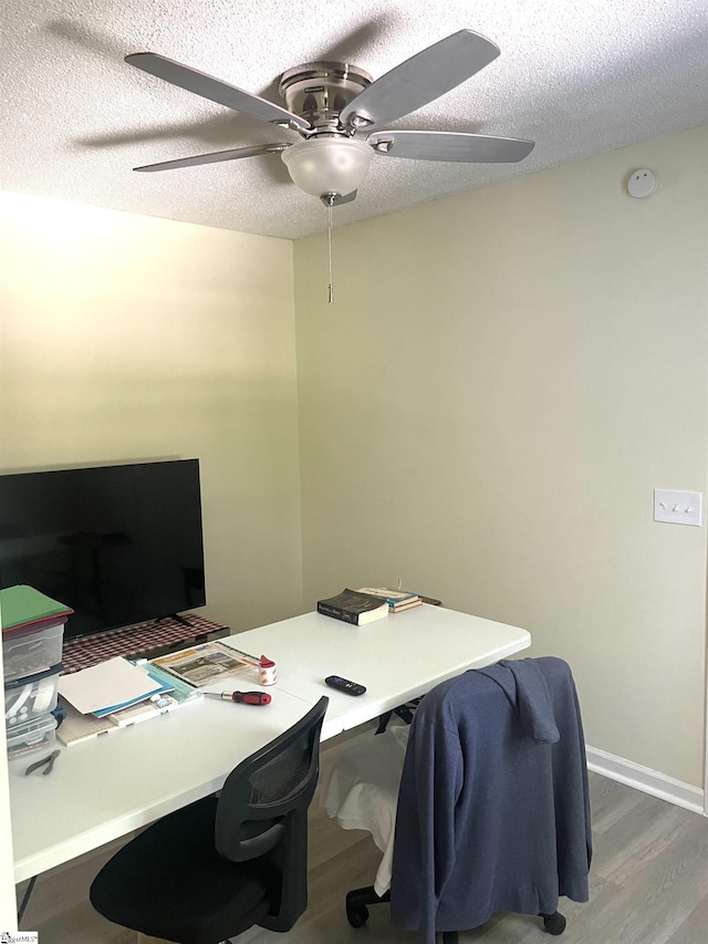 office space featuring ceiling fan, hardwood / wood-style flooring, and a textured ceiling