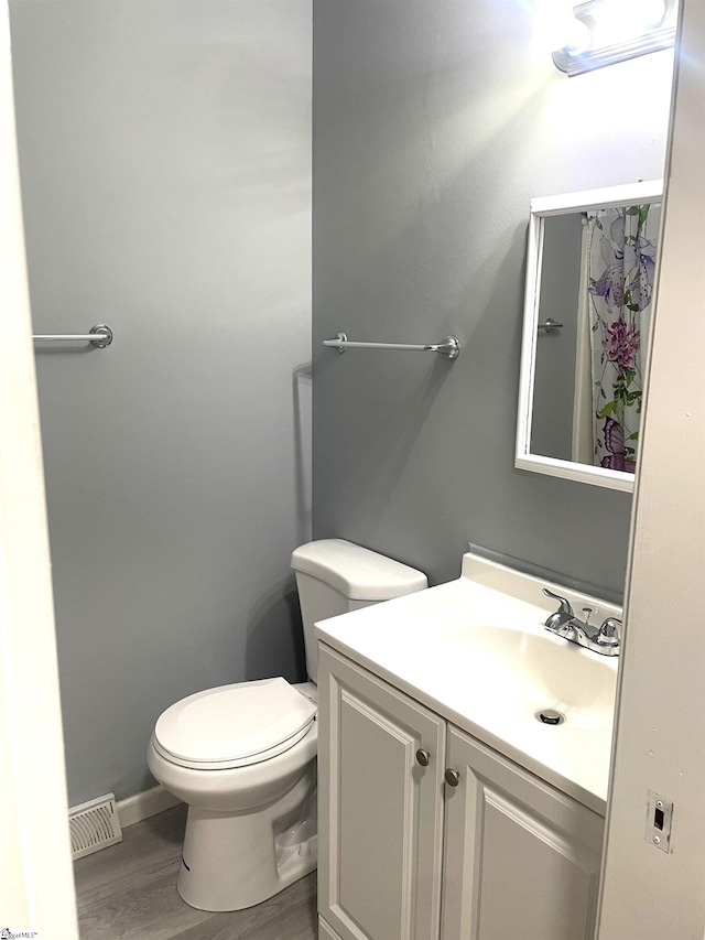 bathroom with vanity, toilet, and wood-type flooring