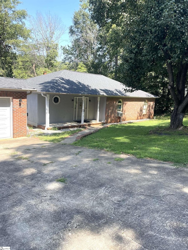 single story home with a front yard, a garage, and a porch