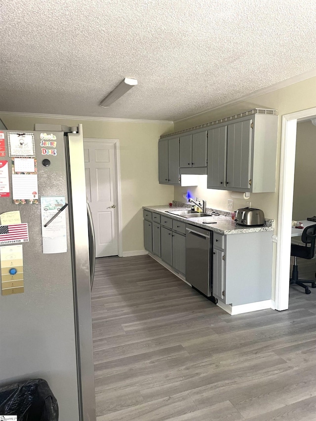 kitchen featuring dark wood-type flooring, stainless steel appliances, and a textured ceiling