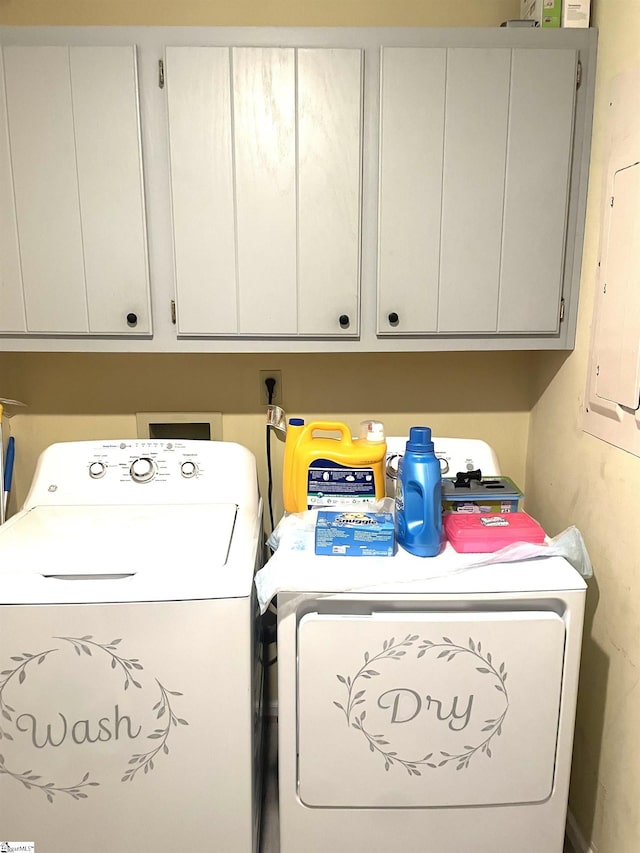 laundry room with separate washer and dryer and cabinets