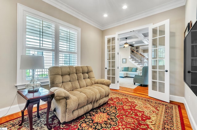 sitting room featuring crown molding, light hardwood / wood-style flooring, ceiling fan, and french doors